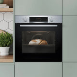 Bosch Series 4 built-in oven with steam function in black, front view, showing bread being cooked